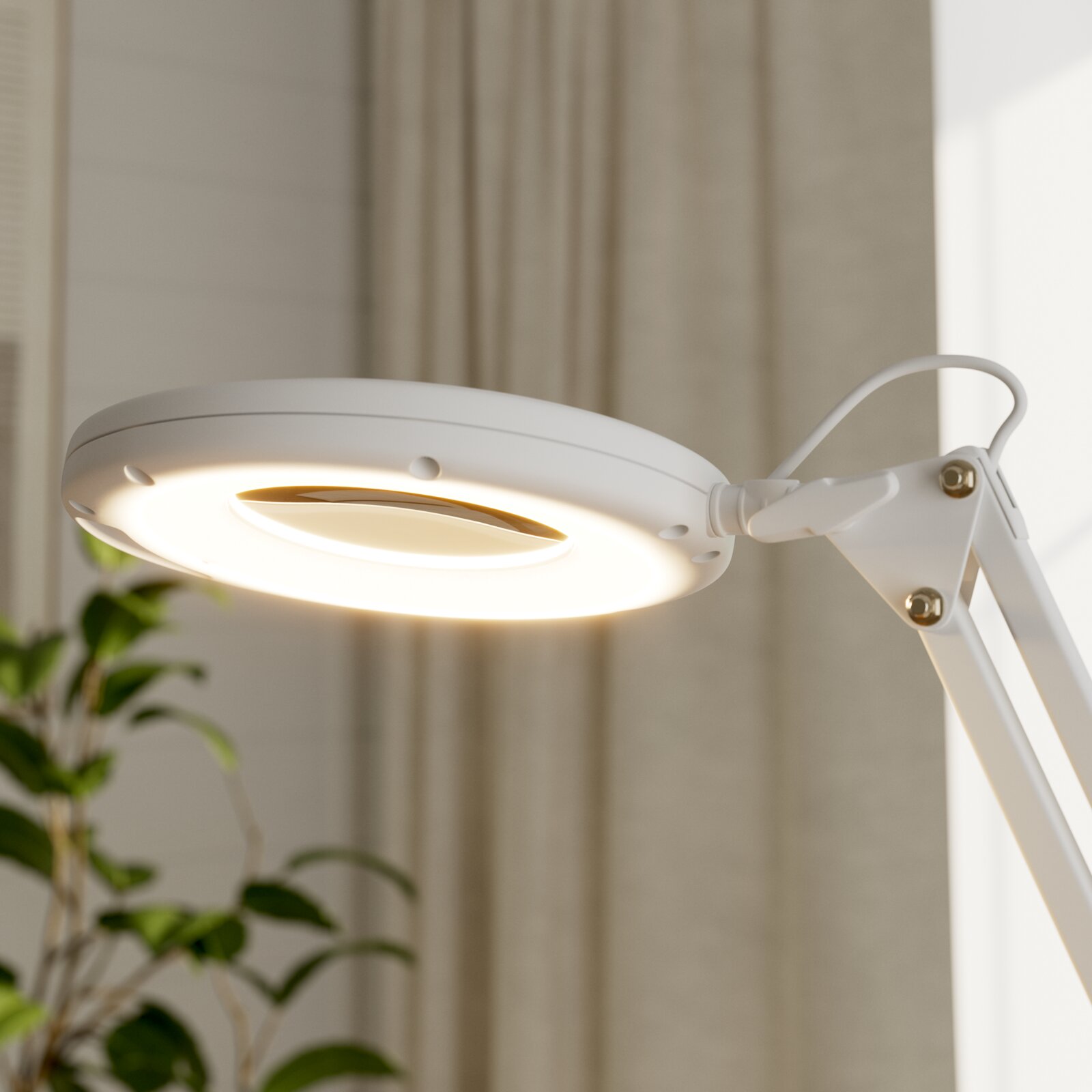 Weiße LED-Schreibtischlampe mit rundem Leuchtkopf und warmem Licht, Detailaufnahme aus seitlicher Untersicht in einem Wohnraum mit Vorhängen und Pflanze im Hintergrund