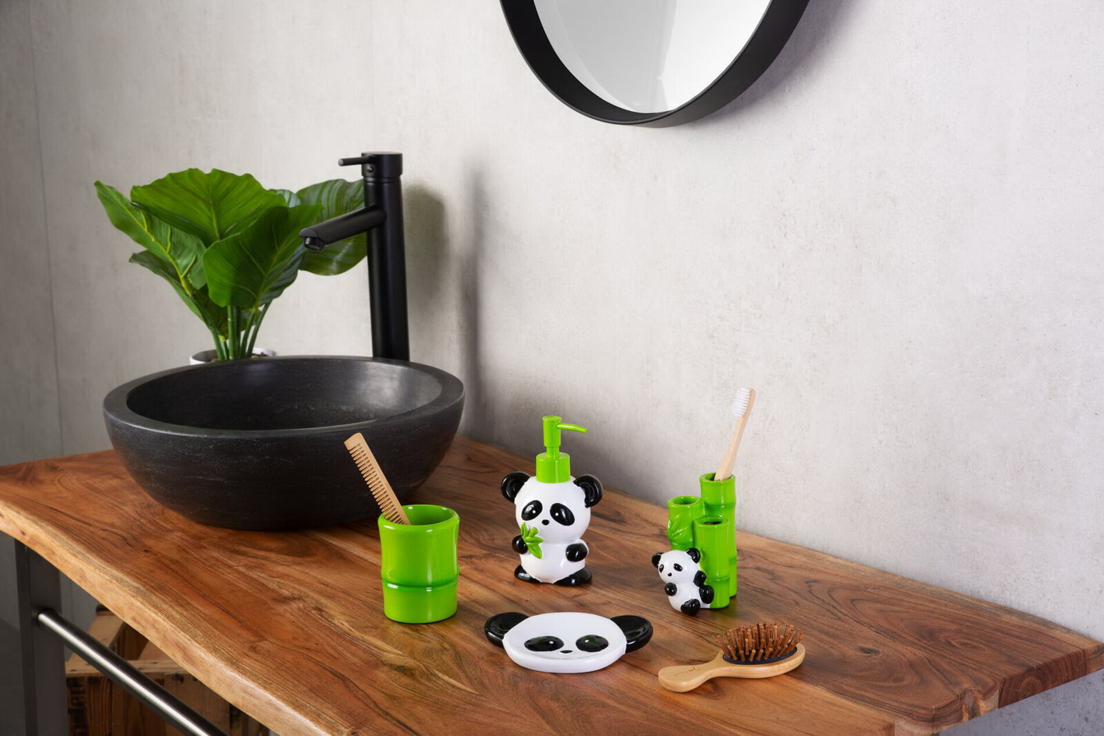 Badezimmer-Accessoires im Panda- und Bambus-Design auf Holzwaschtisch neben schwarzem Aufsatzwaschbecken und schwarzer Armatur, frontal aus leicht schräger Perspektive von vorn