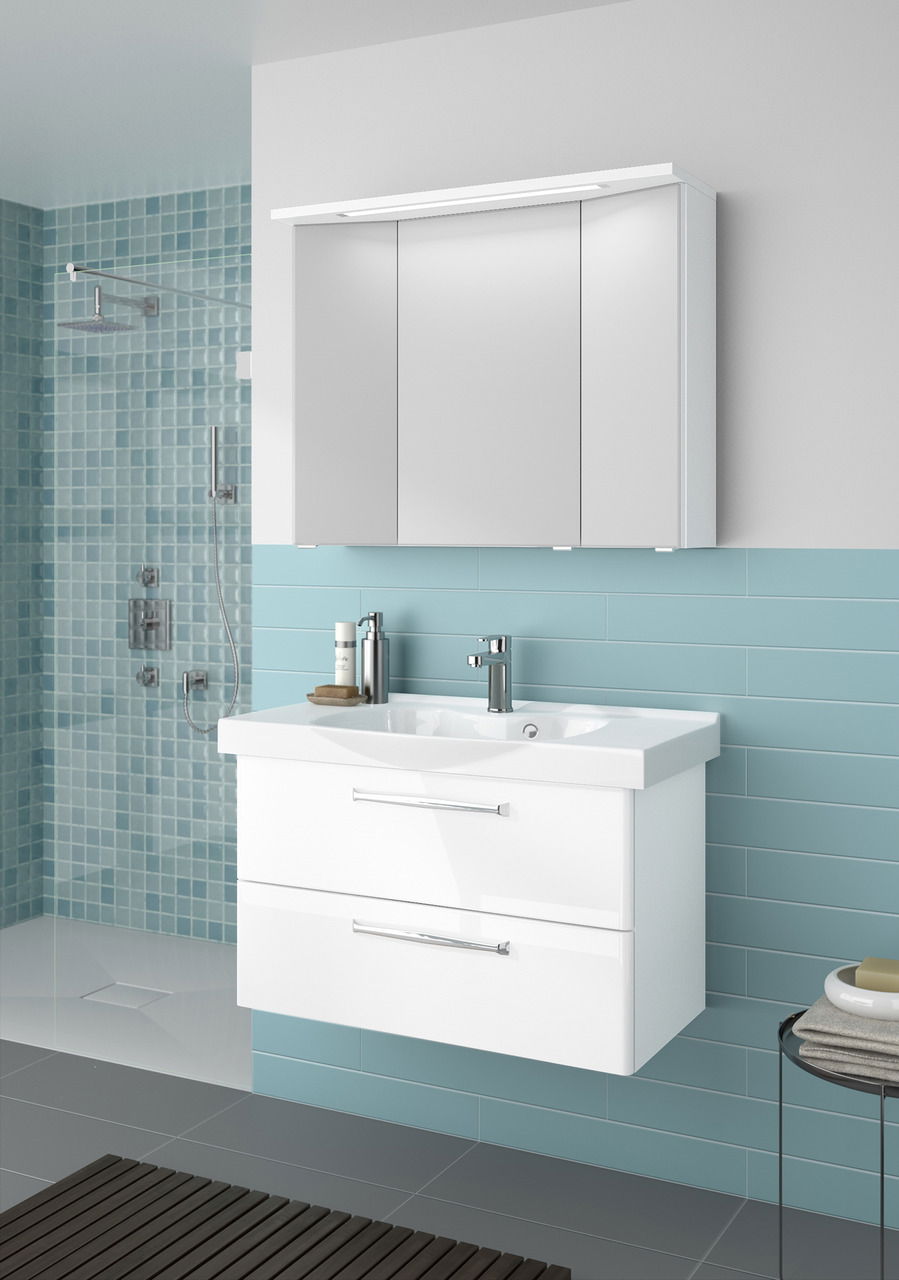 Moderner Badblock mit weißem Waschbecken und Schubladen, frontal betrachtet, vor einer Wand mit blauen Fliesen.