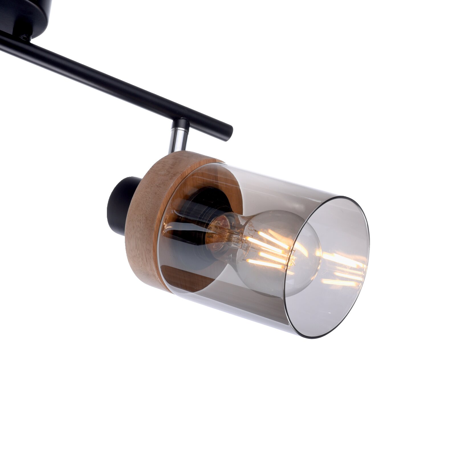 Moderne Decken-Spotleuchte mit schwarzer Schiene, Holzdetails und zylindrischem Rauchglas-Schirm mit sichtbarer LED-Filamentlampe, schräg von unten aus seitlicher Nahaufnahme fotografiert