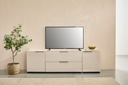 Modernes weißes TV-Lowboard mit zwei Schubladen und seitlichen Türen, darauf ein Flachbildfernseher; Frontansicht in minimalistischer Wohnraum-Szene mit Pflanze links und Deko rechts