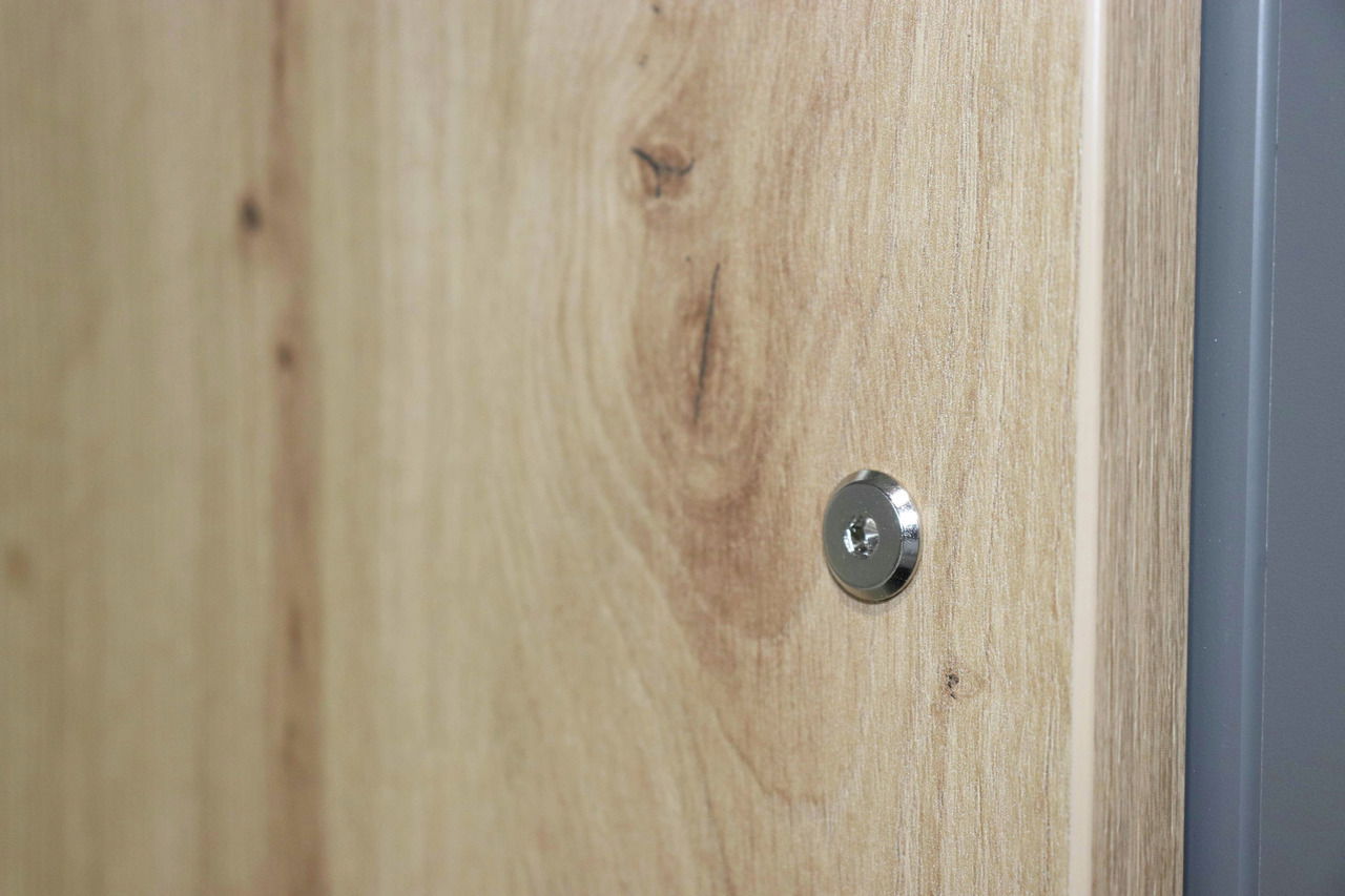 Nahaufnahme einer Holzoberfläche mit sichtbarer Schraube, seitliche Perspektive