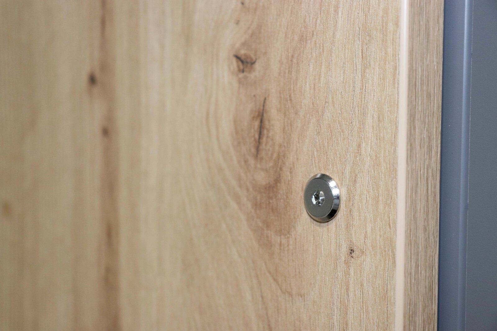 Nahaufnahme einer Holzoberfläche mit sichtbarer Schraube, seitliche Perspektive