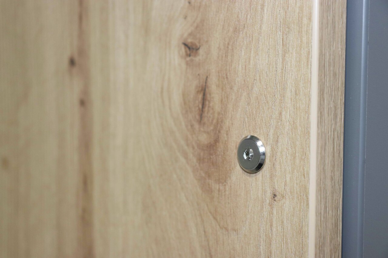 Close-up van een houten oppervlak met zichtbare schroef, zijaanzicht