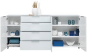Frontale Ansicht eines weißen XL-Sideboards mit offenen Türen und Schubladen, dekoriert mit Vasen, Büchern und Kerzen.
