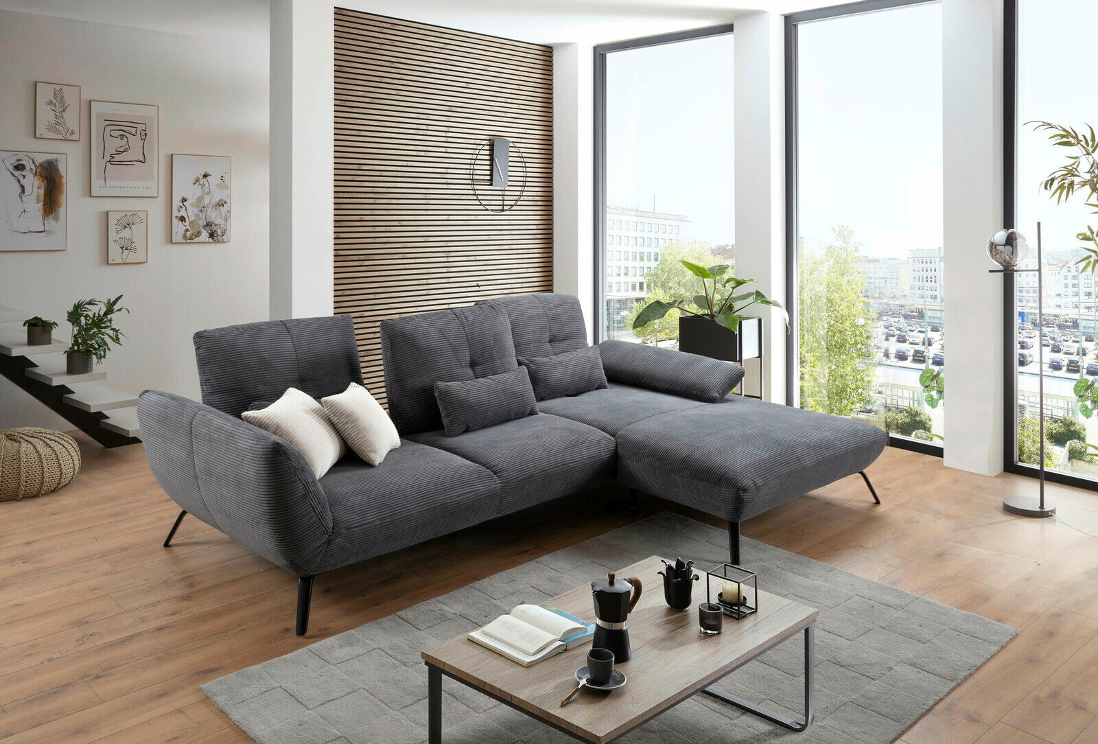 Graue Rundecke in modernem Wohnzimmer mit großen Fenstern, seitliche Perspektive