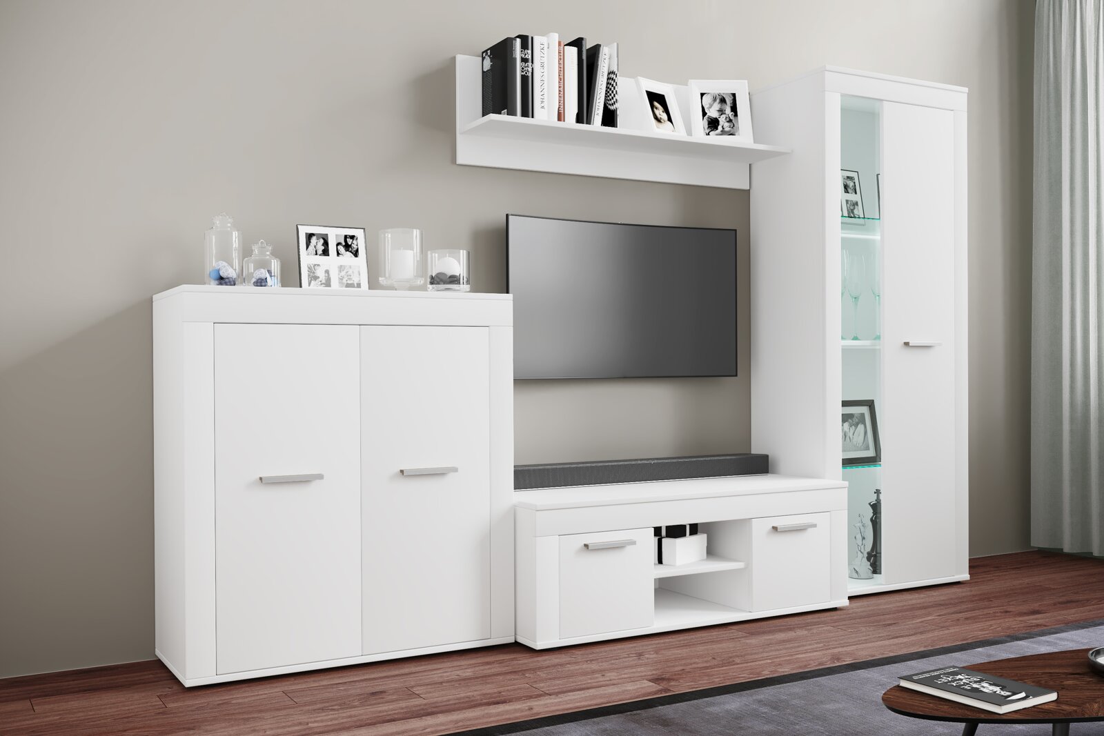Moderne weiße Wohnwand im Wohnzimmer mit TV-Lowboard, hoher Vitrine mit Glastür, Sideboard und Wandregal, frontal aus leicht schräger Perspektive aufgenommen
