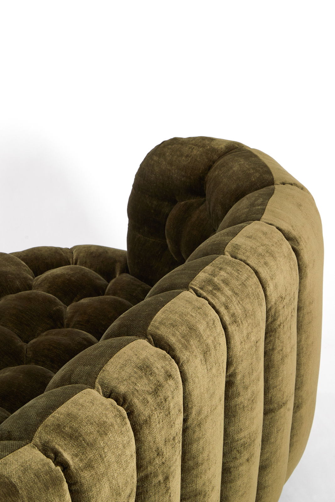 Nahaufnahme einer olivgrünen Couch mit gestepptem Design und weicher Polsterung, seitliche Perspektive.