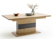 Moderner Esstisch aus Holz mit zentralem Standfuß, dekoriert mit einem Kupferschale, einem Stapel Teller und einer Vase mit Blumen, seitliche Perspektive.