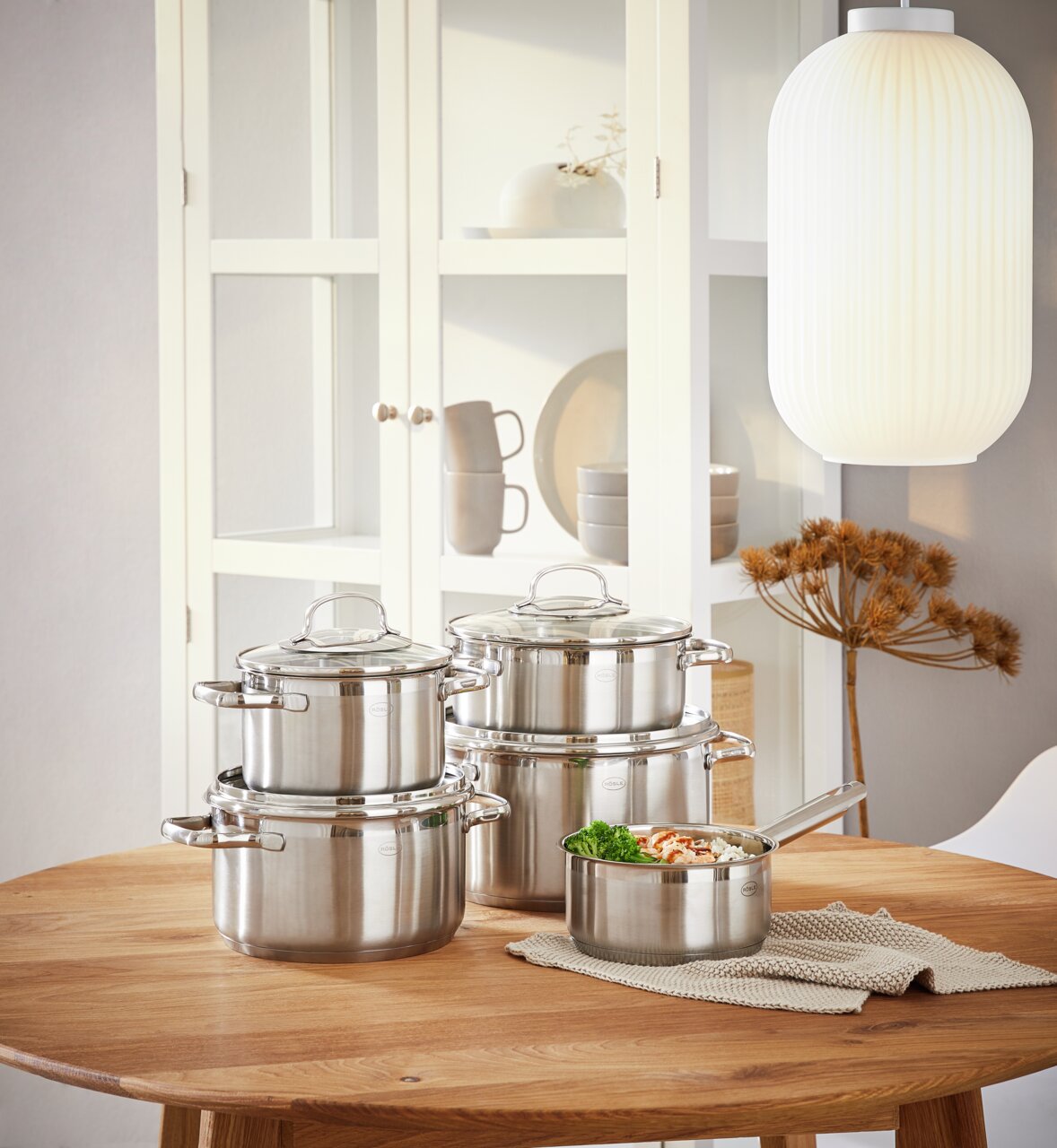 Rösle Topfset 5-tlg. ELEGANCE Elegantes 5-teiliges Topfset aus Edelstahl auf einem Holztisch, seitliche Perspektive.