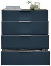 Schubkastenkommode in dunklem Blau mit vier Schubladen, teilweise geöffnet, aus frontaler Perspektive. Dekoriert mit Büchern und einer Vase auf der Oberseite.