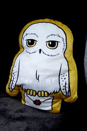 Eule-Formkissen mit gelbem Rand, frontal abgebildet, hält einen Brief mit rotem Siegel.