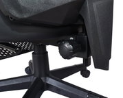 Close-up van de onderkant van een gamingstoel, met de nadruk op het mechanisme en de wieltjes, gezien vanaf de zijkant.