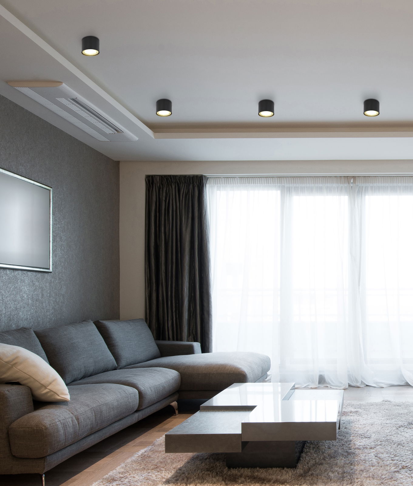 Moderne schwarze Deckenleuchte aus Metall in einem stilvollen Wohnzimmer, von unten betrachtet.