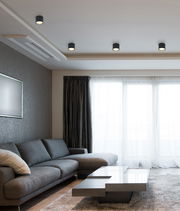 Moderne schwarze Deckenleuchte aus Metall in einem stilvollen Wohnzimmer, von unten betrachtet.