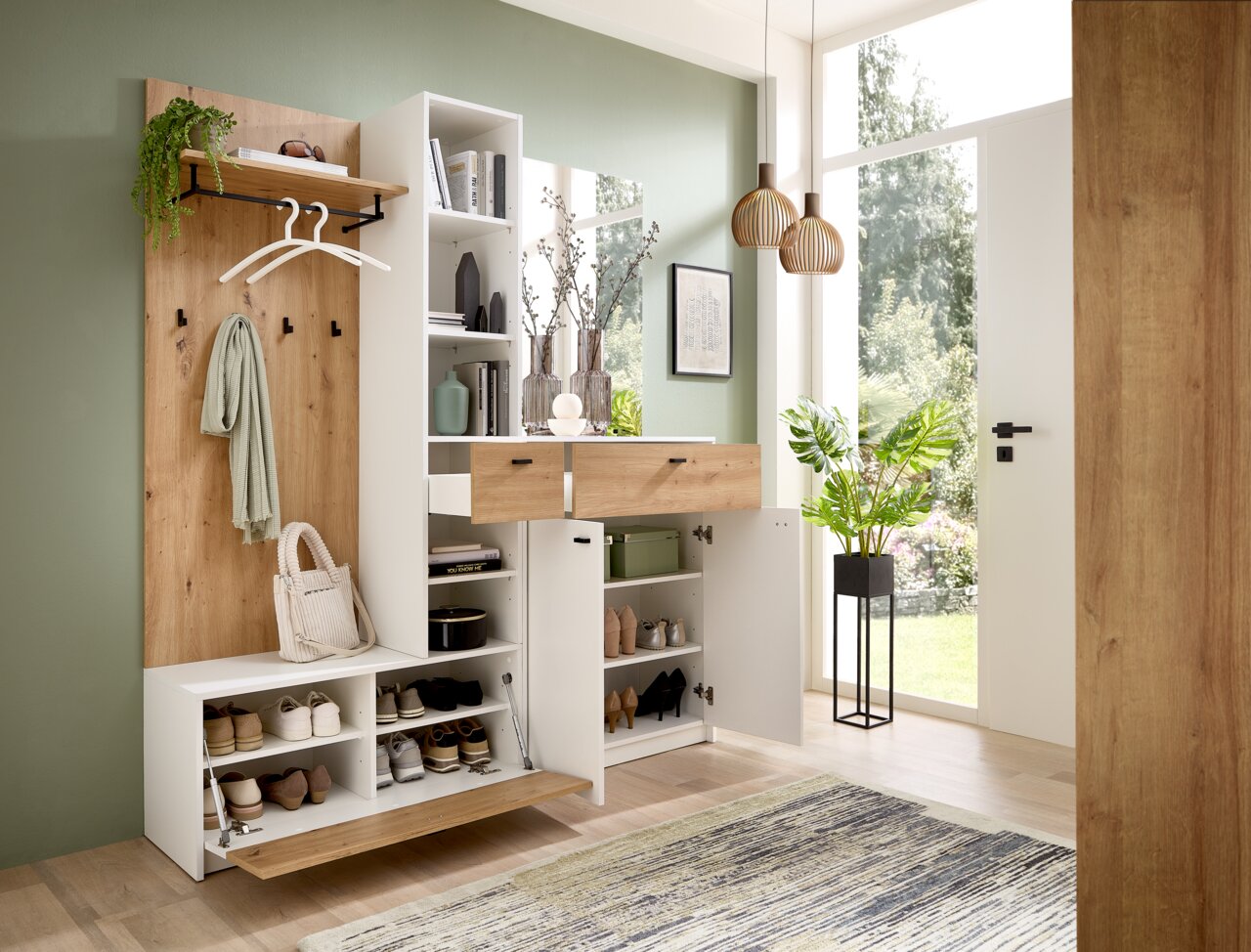 Moderne Kompaktgarderobe in einem hellen Raum, mit Holz- und weißen Elementen, Schuhregalen, Kleiderhaken und Schubladen, aus der Perspektive des Eingangsbereichs betrachtet.