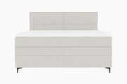 Frontale Ansicht eines modernen Boxspringbetts in hellem Stoffbezug mit schlichtem Design und schwarzen Füßen.