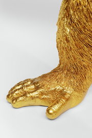 Nahaufnahme einer goldenen Affenpfote von der Deko-Figur Butler Chimp, seitliche Perspektive.
