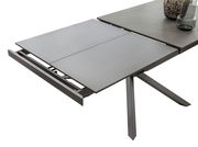 Erweiterbarer Esstisch TOKYO von Zurbrüggen in moderner Perspektive, teilweise ausgezogen mit grauer Tischplatte und stabilen Metallbeinen.