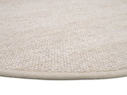 Nahaufnahme eines handgewebten Teppichs in natürlichem Beige, von der Seite fotografiert.