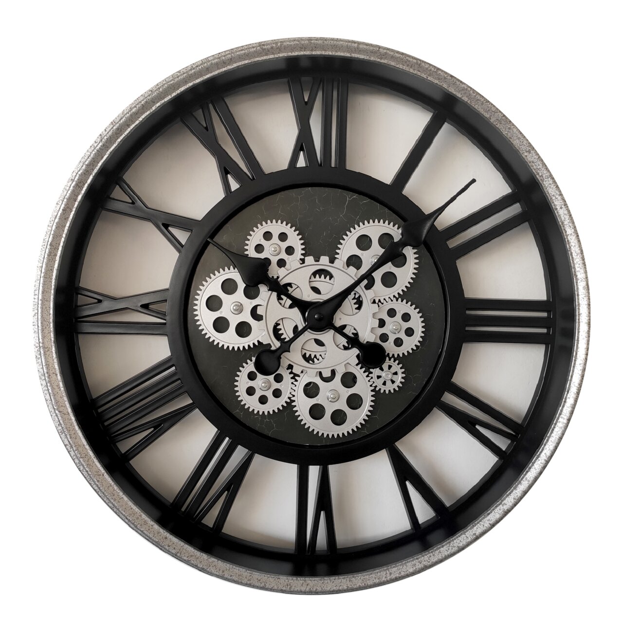 Große Wanduhr mit römischen Ziffern und sichtbaren Zahnrädern, frontal abgebildet.
