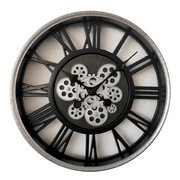 Große Wanduhr mit römischen Ziffern und sichtbaren Zahnrädern, frontal abgebildet.