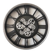 Große Wanduhr mit römischen Ziffern und sichtbaren Zahnrädern, frontal abgebildet.