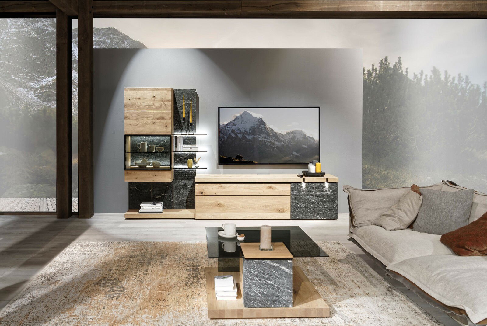 Moderne Wohnwand V-ROCK mit Stein- und Holzelementen, inklusive Beleuchtung und TV, aus frontaler Perspektive.