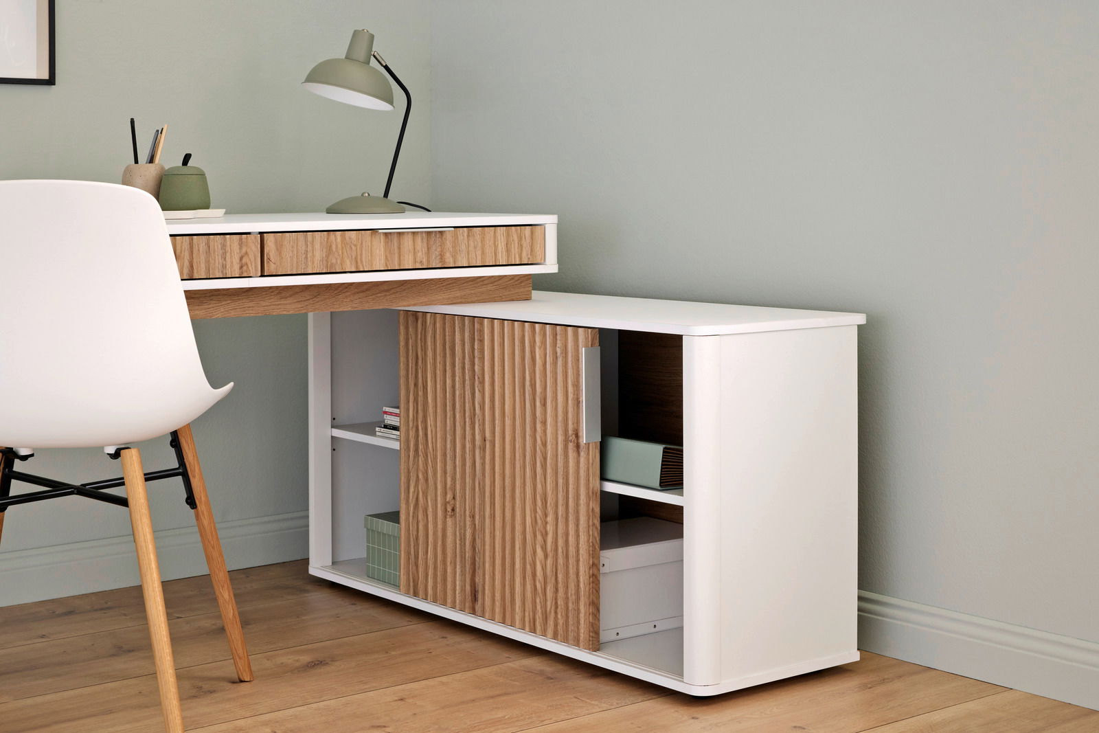 Moderner Eck-Schreibtisch mit Anbau, aus Holz und Weiß, mit Schubladen und Regalfächern, seitliche Perspektive.