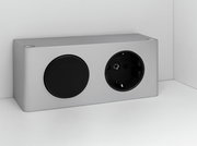 Silberne Steckdose mit schwarzem Abdeckknopf, seitliche Perspektive