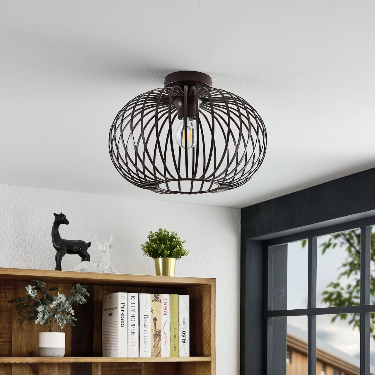 Moderne plafondlamp met een zwart draadkooiontwerp, gezien van onderaf.
