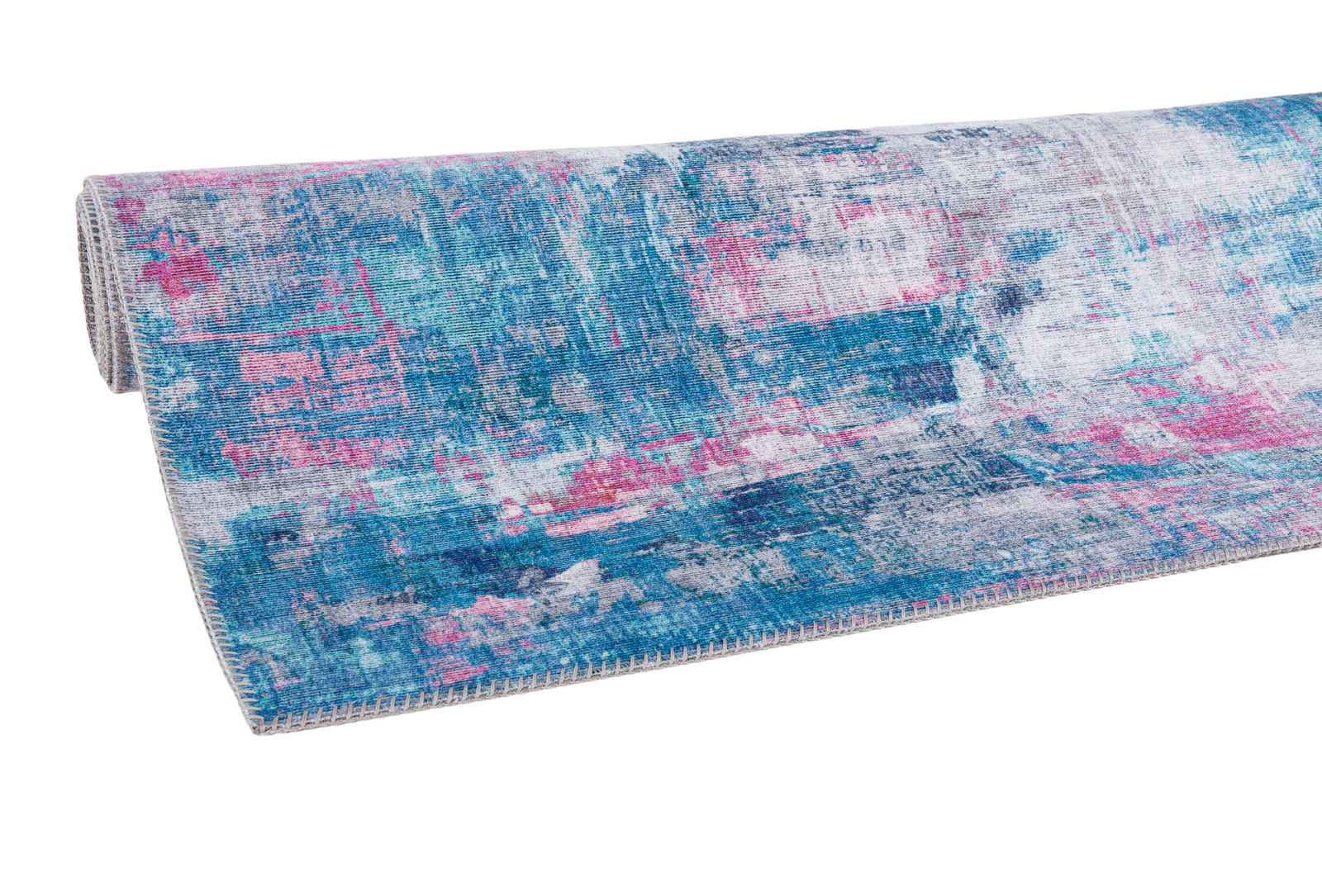 Teppich in Blau- und Pinktönen, teilweise aufgerollt, aus seitlicher Perspektive fotografiert