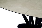 Moderne eettafel met een lichtgekleurd tafelblad en een zwart, geometrisch onderstel, zijaanzicht