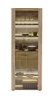 Vitrine aus Holz mit Glastüren, beleuchtet, gefüllt mit Geschirr und Gläsern, frontal betrachtet.