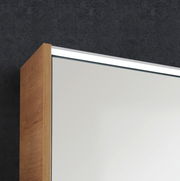 Nahaufnahme eines Badezimmerspiegels mit Holzrahmen und integrierter Beleuchtung, seitliche Perspektive