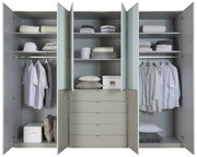 Geöffneter Funktionsdrehtürenschrank mit mehreren Fächern und Schubladen, gefüllt mit Kleidung und Accessoires, frontale Ansicht.