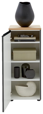 Kommode LENDINA von Dieter Knoll mit geöffneter Tür, zeigt Innenregale mit Büchern, Dekorboxen und Vasen, aus frontaler Perspektive.
