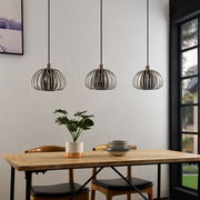 Drei moderne Hängeleuchten mit Metallkäfig-Design über einem Esstisch, seitliche Perspektive.
