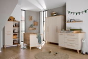 Moderne, vierdelige kledingkast in een stijlvolle kinderkamer, gezien vanaf de voorkant.