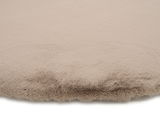 Nahaufnahme eines beigen Fellteppichs mit weicher, flauschiger Textur.