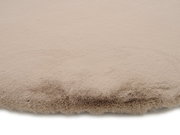 Nahaufnahme eines beigen Fellteppichs mit weicher, flauschiger Textur.