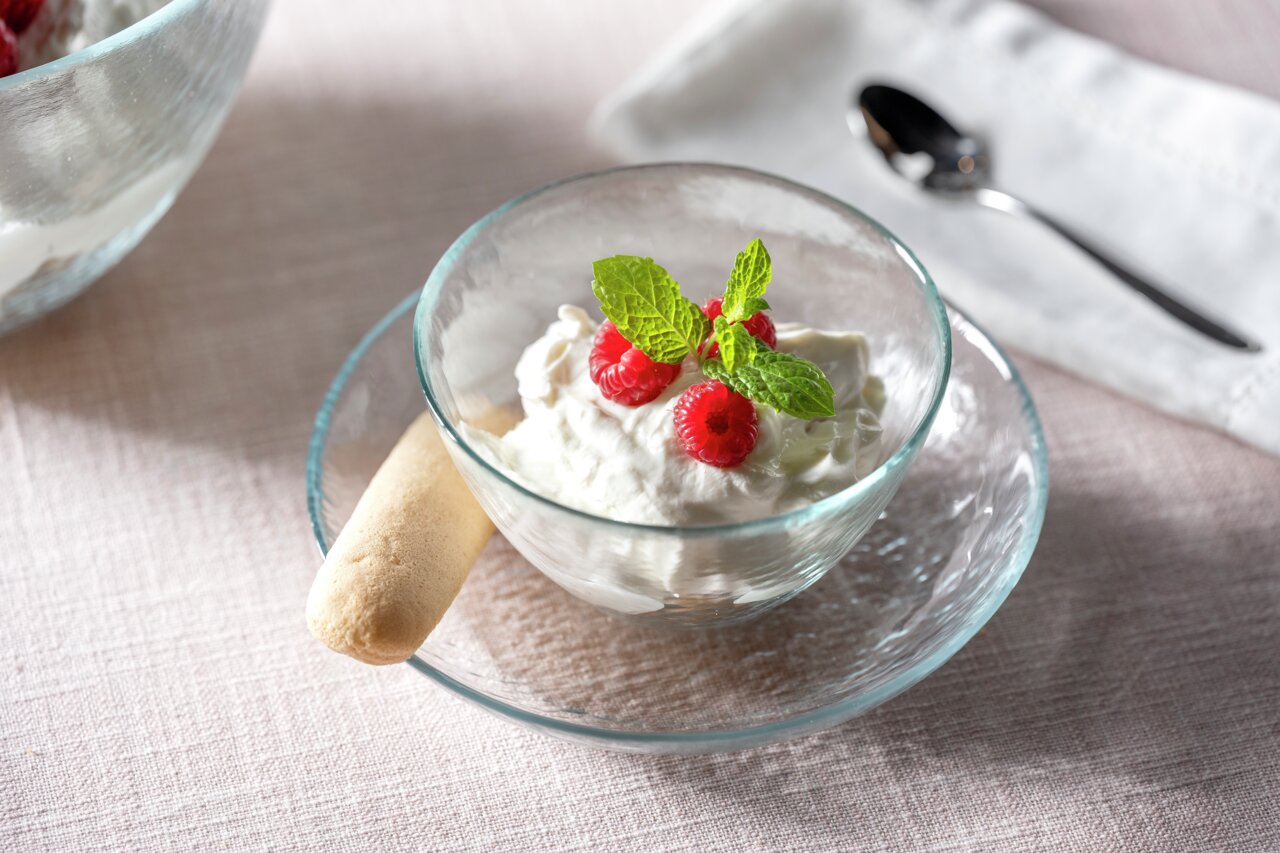 Glas-Schale Attivo 12cm mit Dessert, dekoriert mit Himbeeren und Minzblättern, von oben fotografiert.