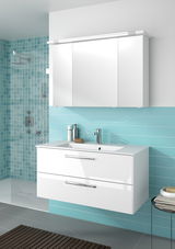 Moderner weißer Badblock mit zwei Schubladen und integriertem Waschbecken, vor einer türkisfarbenen Wand mit Fliesen, aus der Perspektive von vorne betrachtet.