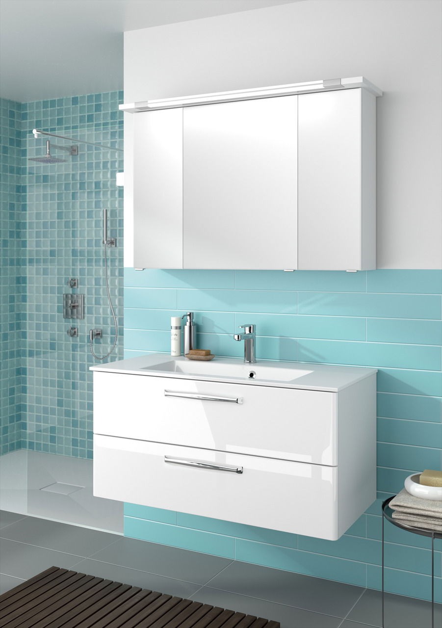 Moderner weißer Badblock mit zwei Schubladen und integriertem Waschbecken, vor einer türkisfarbenen Wand mit Fliesen, aus der Perspektive von vorne betrachtet.