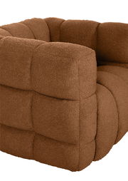 Nahaufnahme eines braunen Drehsessels mit weicher, gepolsterter Oberfläche und quadratischem Muster, seitliche Perspektive.