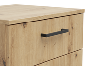 Nahaufnahme einer Kommode aus hellem Holz mit schwarzem Griff, seitliche Perspektive