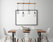 Moderne Hängeleuchte mit vier Glühbirnen, hängend über einem Esstisch aus Holz, seitliche Perspektive.