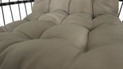 Nahaufnahme eines gepolsterten Hängesessels in beige aus seitlicher Perspektive.