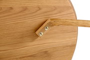 Nahaufnahme eines Couchtischs aus Holz mit sichtbarer Tischplatte und einem Tischbein, von oben betrachtet.