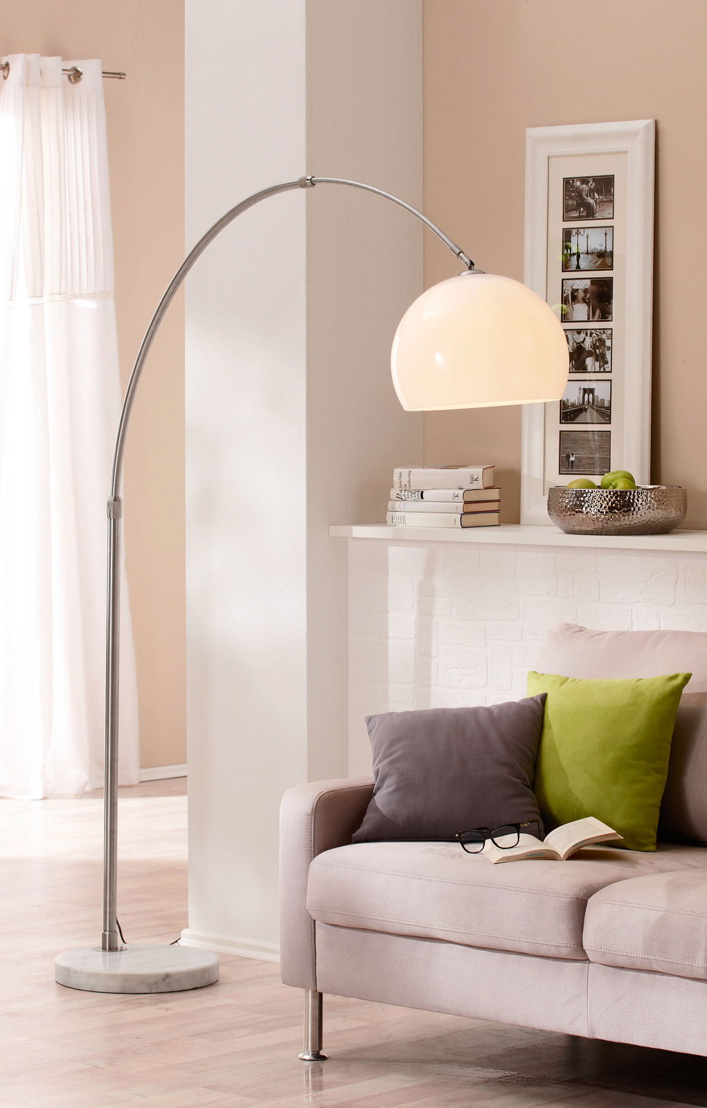 Bogenleuchte mit gebogenem Metallgestell und großem, halbkugelförmigem Lampenschirm in einem modernen Wohnzimmer, seitliche Perspektive.